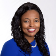 Gwen, a Black woman with black curly hair, wears a royal blue blouse and silver necklace.